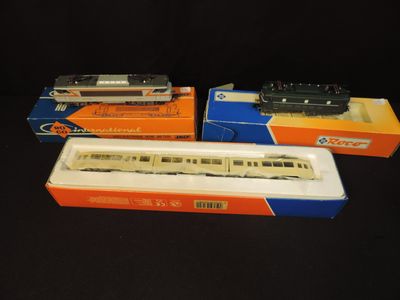 three model trains in boxes on a black surface