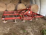 a tractor that is parked next to hay bales