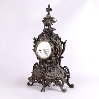 une horloge posée sur un support sur fond blanc