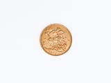 a close up of a gold coin on a white surface
