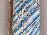 an old book with a blue cover sitting on top of a table