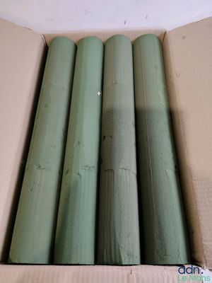 a cardboard box that has a bunch of green pipes in it