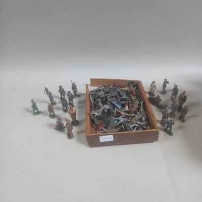 plein de petits soldats de plomb dans une boîte en bois