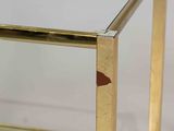 a glass table with a gold metal frame and a glass top