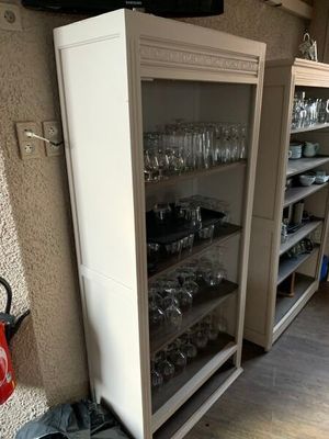 un grand placard sur lequel sont posés de nombreux verres, dans la cuisine