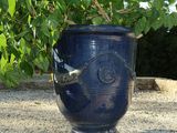 a large blue vase sitting on a gravel ground