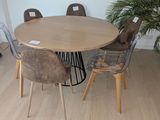 une table et des chaises dans une pièce où se trouve une plante