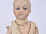 a small doll that is sitting on a white surface
