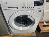 une machine à laver posée sur une palette dans un entrepôt