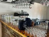 bottles and glasses are lined up on a bar in a restaurant