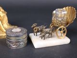 a small statue of a horse pulling a carriage next to a small box with a horse and carriage on it