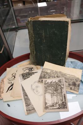 de nombreux livres anciens posés sur une table, avec une vitrine en arrière-plan