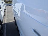 a white van parked in a parking lot next to a white van