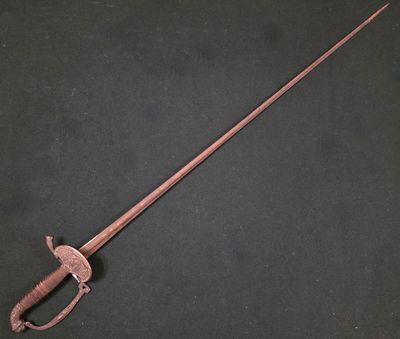 une vieille épée avec une poignée en bois sur un fond noir