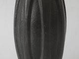 a black vase that is sitting on a white surface