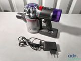 a vacuum that is sitting on a table next to a charger