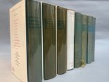 several books are lined up in a row on a white surface