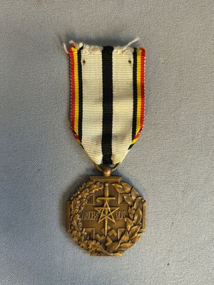 une photo représentant une médaille entourée d'un ruban, posée sur une table