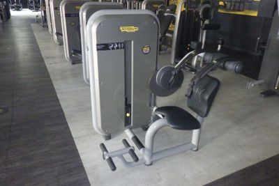 une rangée d'appareils d'exercice dans une salle de sport