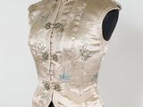 une robe de mannequin avec une veste en brocart doré et argenté