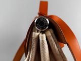 the back view of a tan and brown bag with a leather handle