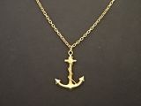 un collier avec une ancre dorée sur fond noir