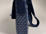 the back view of a small blue bag with a strap on it