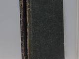 an old book sitting on top of a white shelf next to a window