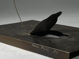 a sculpture of a bird that is sitting on top of a book