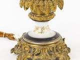 a gold and blue vase on a stand with a bunch of flowers