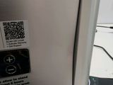 a close up of a silver refrigerator with a qr code on it