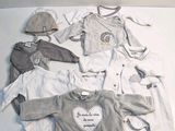 beaucoup de vêtements de bébé étalés par terre