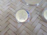 three coins sitting on top of a woven table next to each other