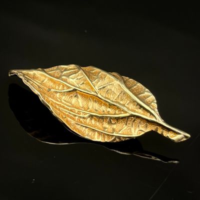 broche en feuille d'or sur fond noir avec reflets