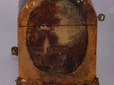 a small wooden box with a painting on it