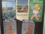 three posters on the wall of a public restroom