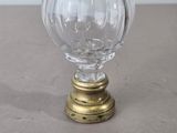 une boule de verre posée sur un socle en laiton, sur une table