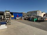 beaucoup de bric-à-brac dans une cour où se trouve un bâtiment bleu