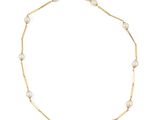 un bracelet en chaîne d'or orné de perles et d'une breloque en forme de croix