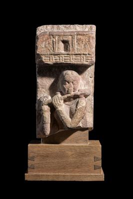 une image représentant une sculpture en pierre d'un homme tenant une bouteille