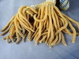 a pile of noodles on a table next to a can of soda