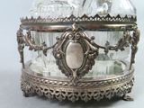 a silver plate with a glass bottle on it