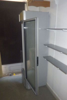 une porte vitrée dans un coin d'une pièce équipée d'étagères