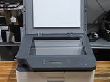 printer sitting on top of a wooden table in front of a shelf