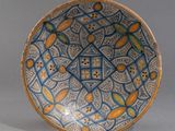 bol orné de motifs bleus, jaunes et orange sur un fond gris