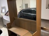 une photo d'une voiture dans un garage, avec un miroir accroché au mur