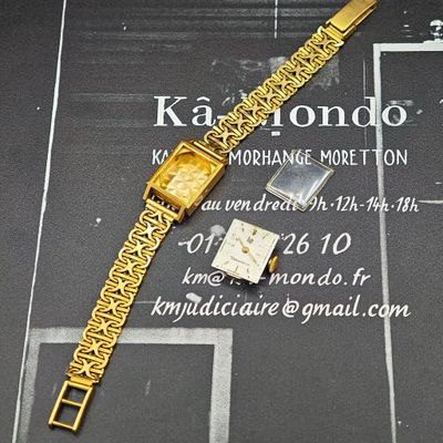 une montre en or et un bracelet en or posés sur une table