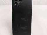 the back of a black iphone case sitting on top of a white table