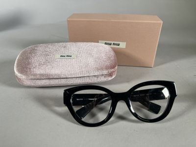 des lunettes de soleil et leur étui posés sur une table à côté d'une boîte rose