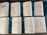 several books with drawings of people on them sitting on a table
